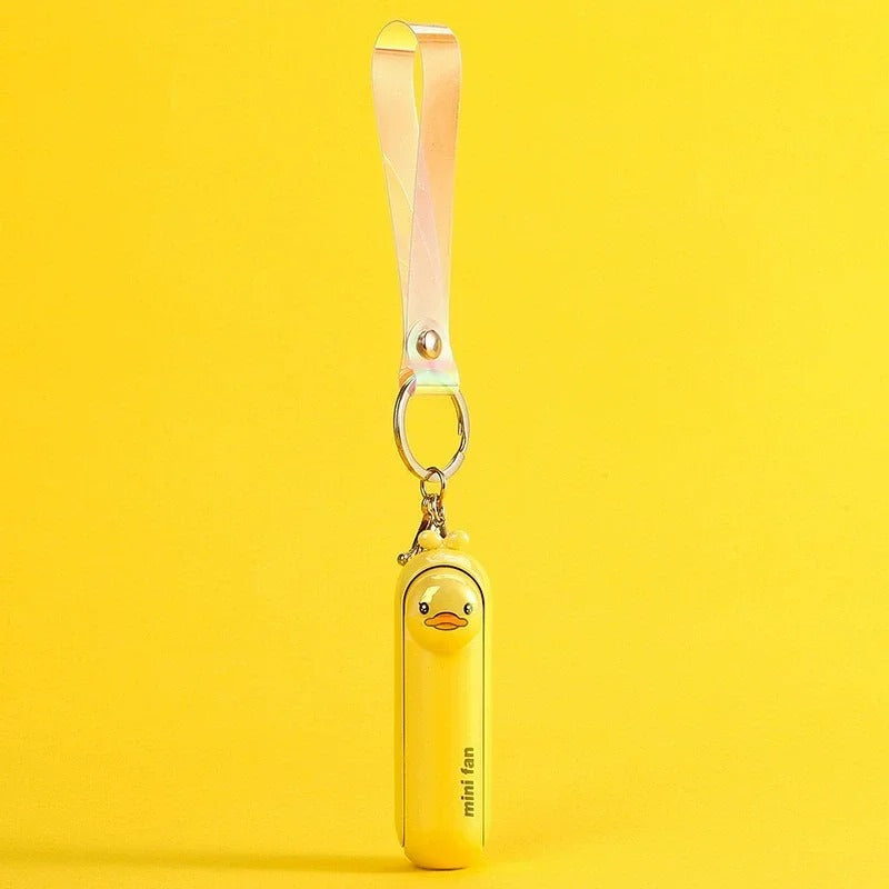 Bright yellow duck design of the Alphinea 3-speed mini fan hanging by a yellow lanyard on a vibrant yellow background.