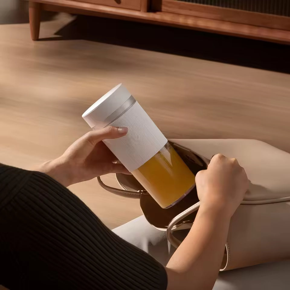 A woman placing the compact, travel-friendly Alphinea portable blender into her handbag. Perfect for lightweight, on-the-go nutrition at the gym or while traveling.