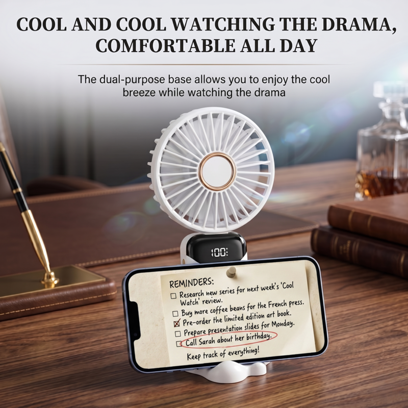 Alphinea handheld fan being used as a built-in phone stand on a desk for hands-free video watching.