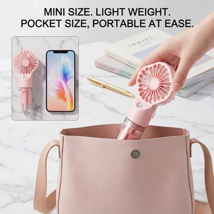 A hand placing the pink Alphinea mini water spray hand fan into a small purse to show its portable size.