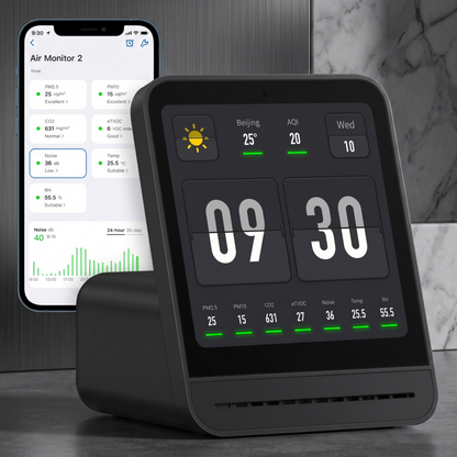 Le moniteur Alphinea Air Monitor 2 noir est associé à un smartphone et affiche l'application mobile associée pour le suivi et la gestion à distance de la qualité de l'air intérieur.