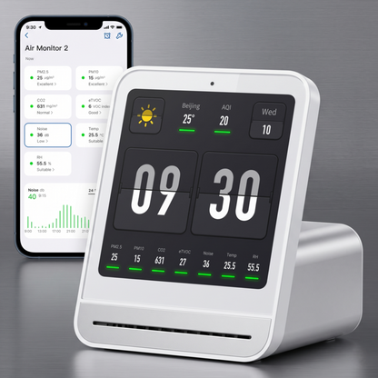 Le moniteur Alphinea Air Monitor 2 blanc est associé à un smartphone et affiche l'application mobile associée pour le suivi et la gestion à distance de la qualité de l'air intérieur.
