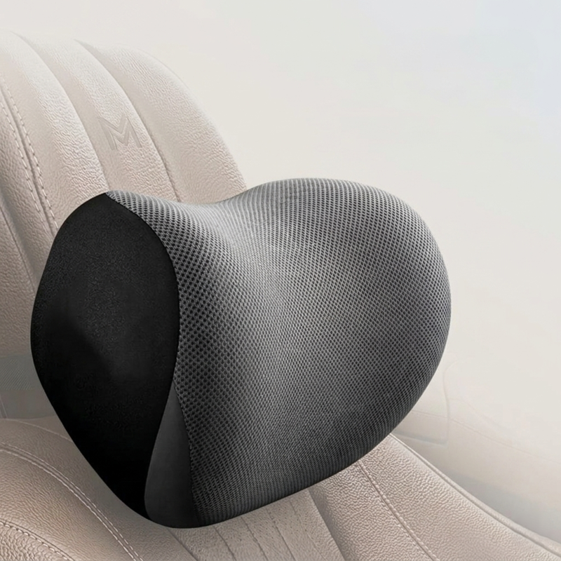 Close-up of the black Alphinea memory foam car neck support pillow on a beige seat, showcasing its U-contour design engineered to seamlessly fill the headrest gap.
