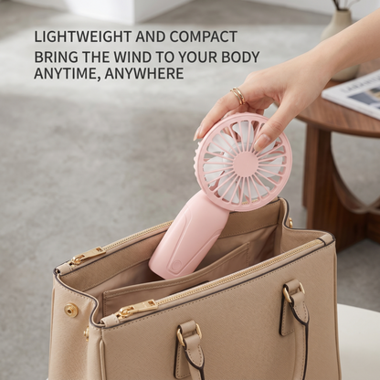 A person easily packing the compact Alphinea portable mini fan into a purse, demonstrating its lightweight and travel-ready size for on-the-go cooling.
