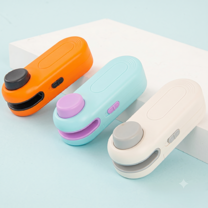 Trois mini-scelleuses thermiques portables Alphinea disposées en diagonale, présentant les coloris modernes disponibles : orange vif, bleu clair et blanc éclatant