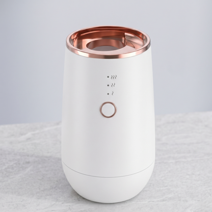Photo studio impeccable du diffuseur de parfum portable Alphinea blanc pour la maison et la voiture, orné de finitions en or rose de qualité supérieure.