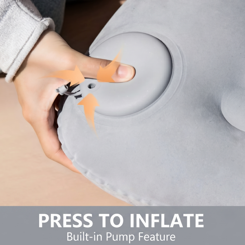 Close-up of a person using the built-in press-to-inflate pump on the Alphinea travel pillow for quick setup without mouth inflation.