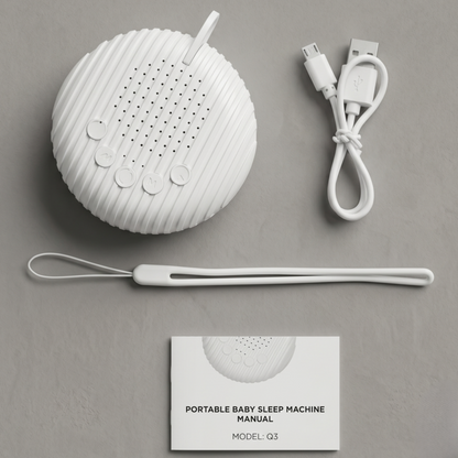Vue à plat du contenu de l'emballage de la machine à bruit blanc Alphinea, comprenant l'appareil, le câble de chargement USB, la dragonne et le manuel d'instructions.